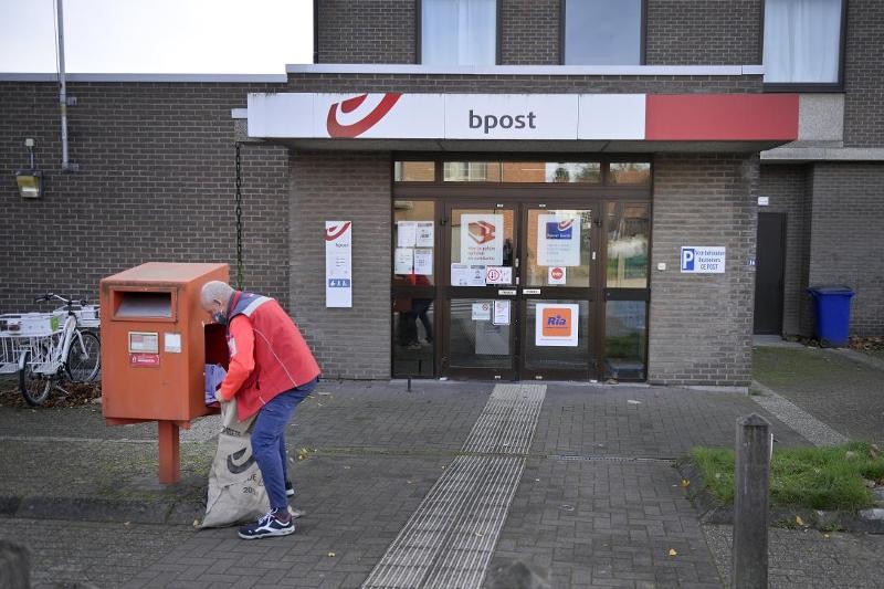 een postbode maakt een postbus leeg