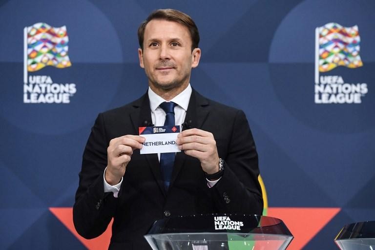 Iemand trekt een strookje papier met 'Nederland' erop