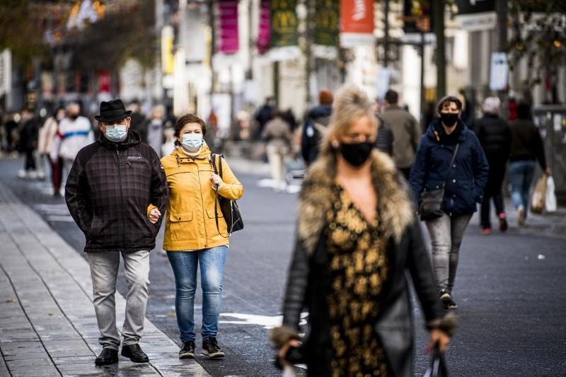 mensen lopen hand in hand, met mondmasker